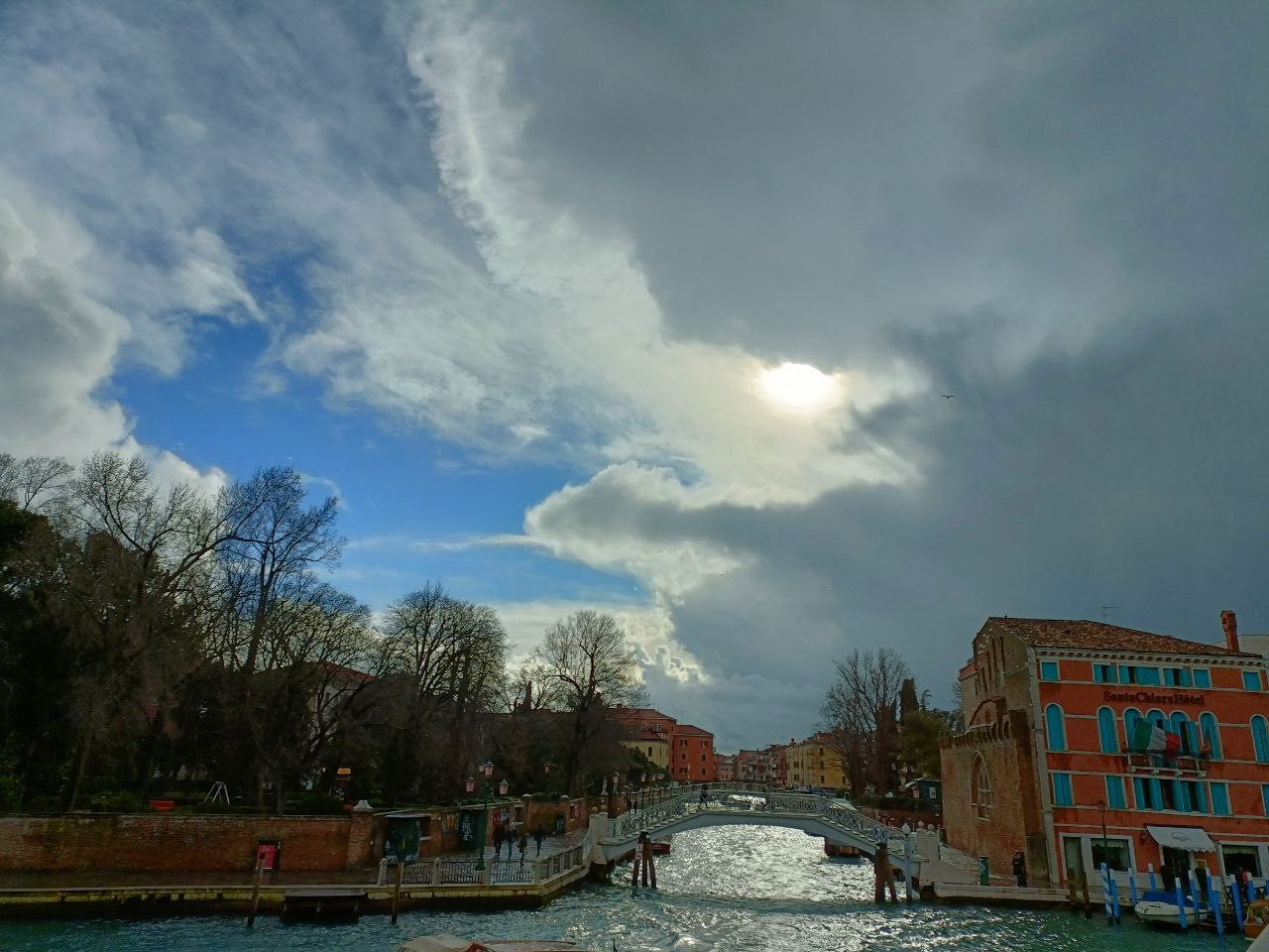 The photo shows Venice during the morning, with the Santa Chiara Bridge in the background. The photo shows Venice during the morning, with the Santa Chiara Bridge in the background.